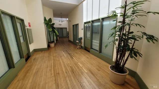 a view of a hallway with wooden floor and staircase