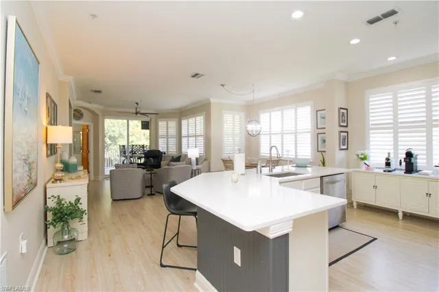 a large kitchen with kitchen island a large counter top space a sink stainless steel appliances and cabinets