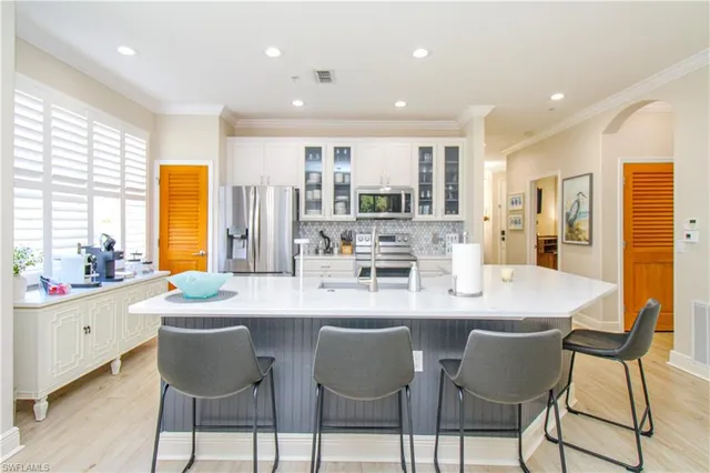 a dining room with stainless steel appliances a table and chairs