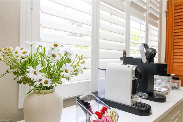 a room with a large window and flower pot