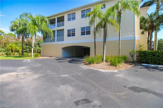 a view of a house with a yard and palm trees
