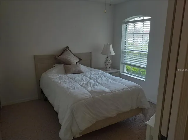 a bed sitting in a bedroom next to a window