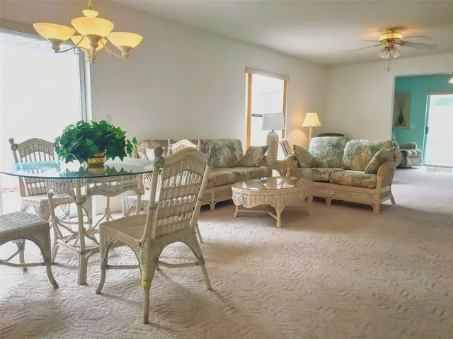 a living room with furniture a chandelier and a window