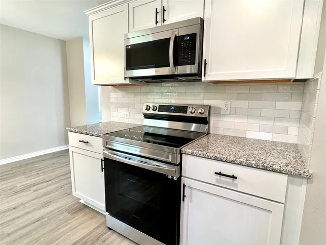 a kitchen with stainless steel appliances granite countertop a stove microwave and oven