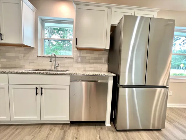 a kitchen with a refrigerator a sink and a window