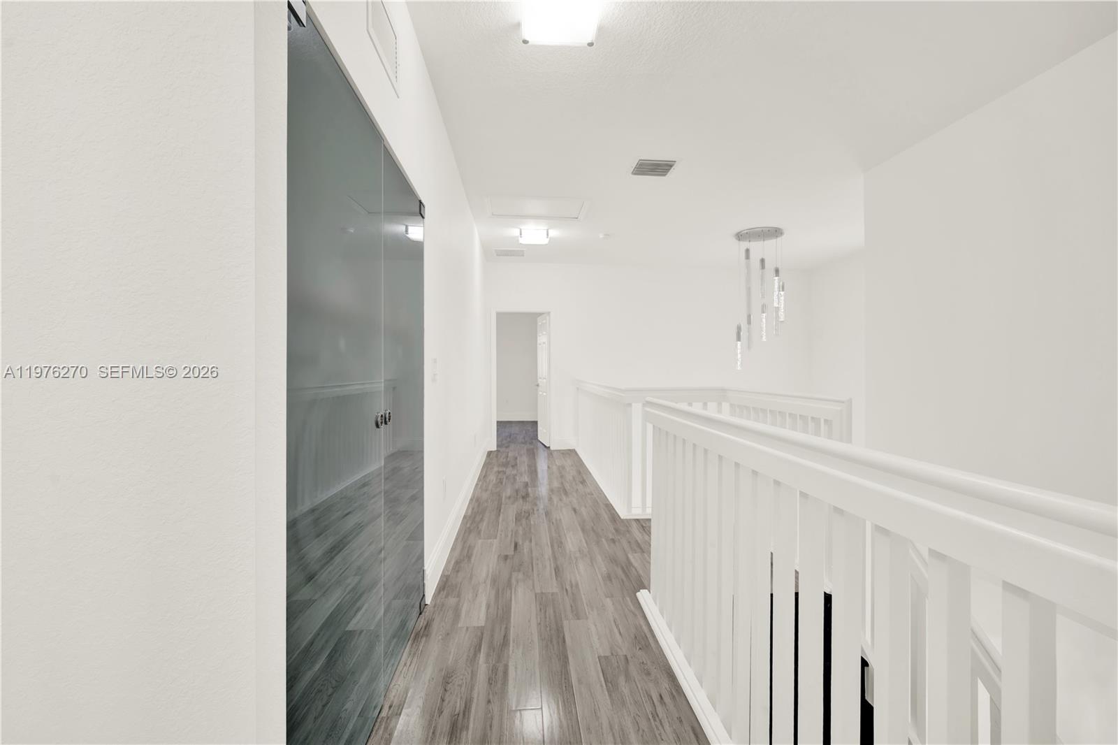 9243 Southwest 227th Terrace Cutler Bay, FL 33190 - Photo 17 of 32 a view of a hallway with wooden floor and staircase