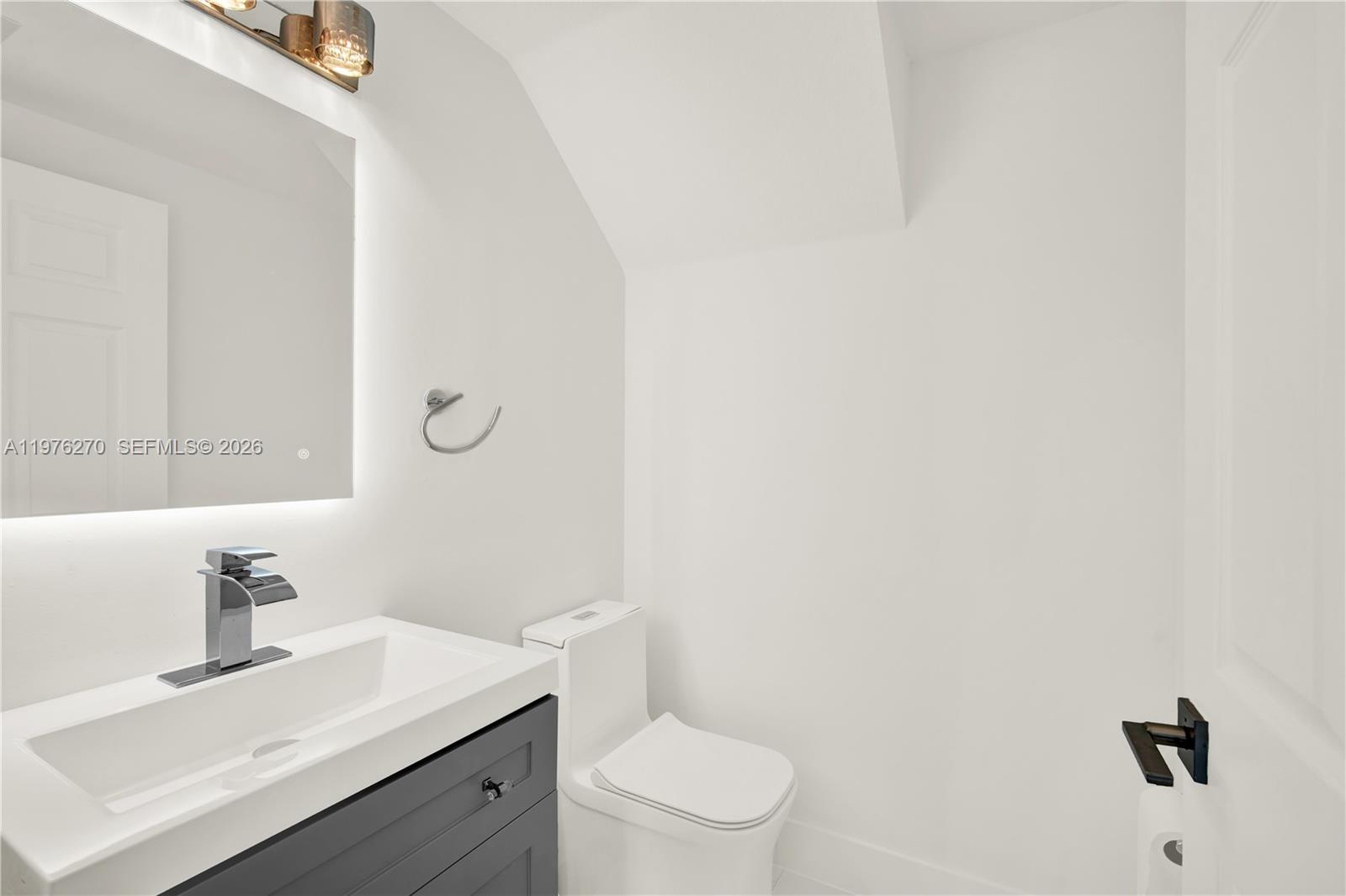 9243 Southwest 227th Terrace Cutler Bay, FL 33190 - Photo 18 of 32 a bathroom with a sink a toilet and mirror