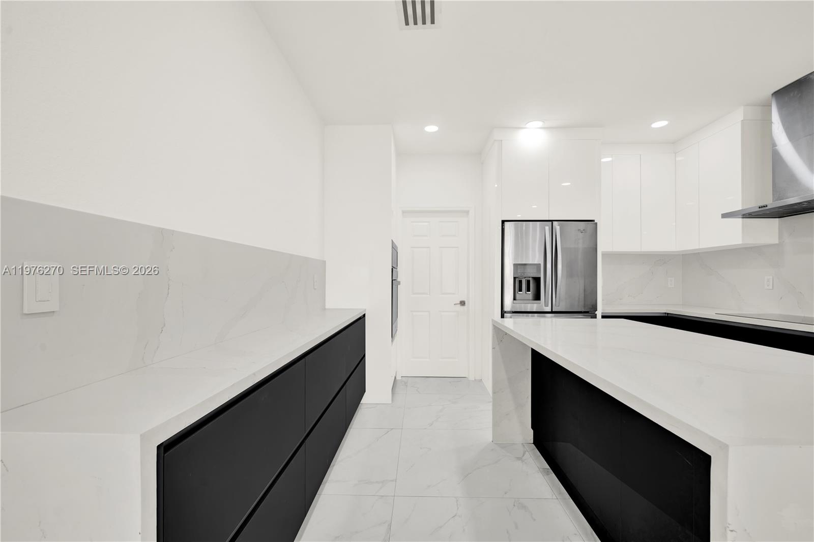 9243 Southwest 227th Terrace Cutler Bay, FL 33190 - Photo 21 of 32 a kitchen with kitchen island a sink wooden floor and refrigerator