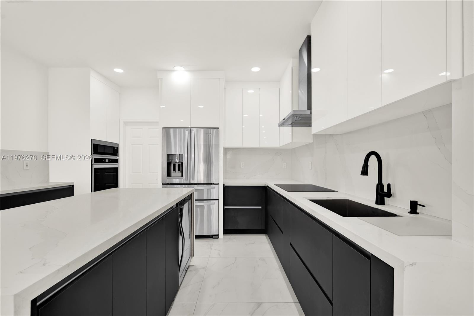 9243 Southwest 227th Terrace Cutler Bay, FL 33190 - Photo 22 of 32 a kitchen with stainless steel appliances a sink stove and refrigerator
