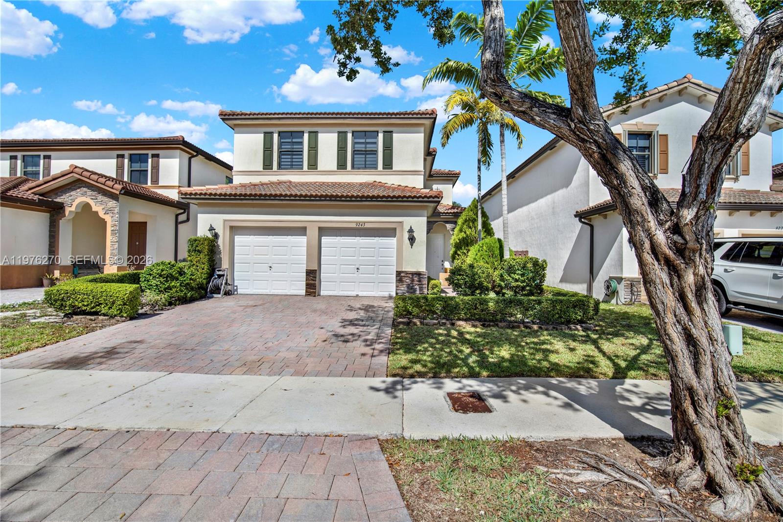 9243 Southwest 227th Terrace Cutler Bay, FL 33190 - Photo 3 of 32 a front view of a house with a yard and a garage