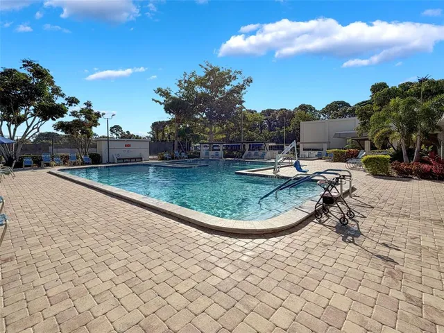 a view of swimming pool with outdoor seating and buildings in the background