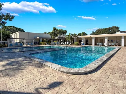 a view of swimming pool with outdoor seating and buildings in the background