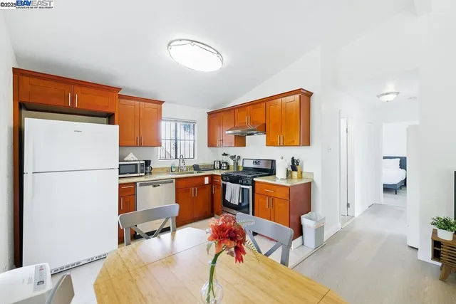 a kitchen with stainless steel appliances granite countertop a kitchen island a stove a table and a refrigerator