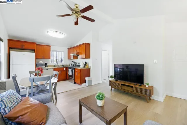 a kitchen with stainless steel appliances granite countertop a refrigerator a sink dishwasher a stove with white cabinets and wooden floor