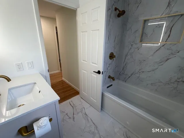 a bathroom with a tub sink and mirror