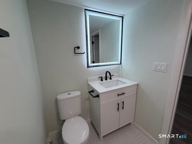 a bathroom with a toilet sink and mirror