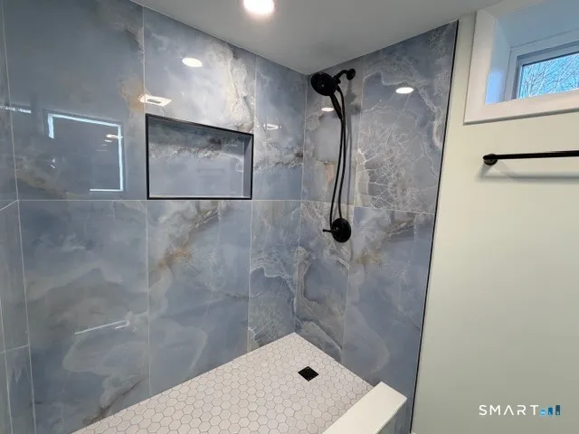 a bathroom with a shower and mirror