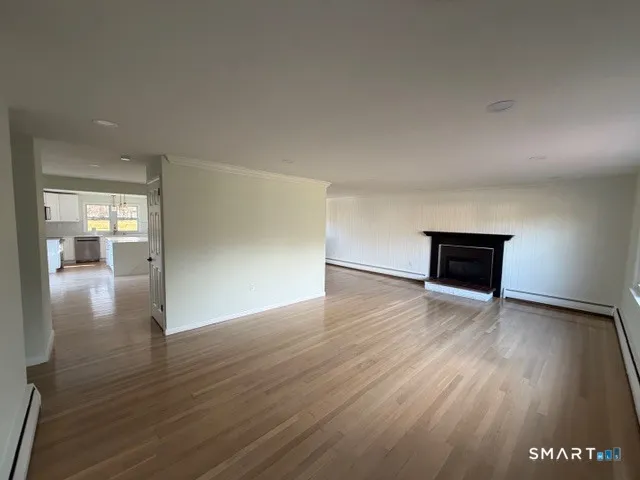 a view of empty room with wooden floor