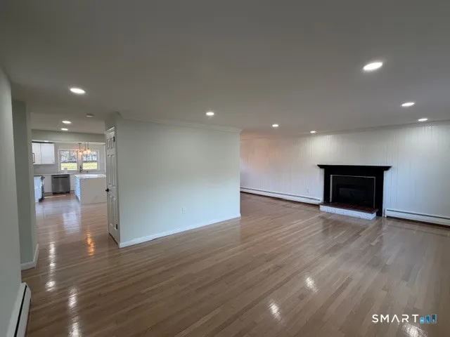 a view of empty room with wooden floor
