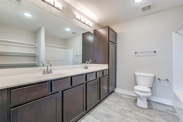 a bathroom with a double vanity sink toilet and a mirror