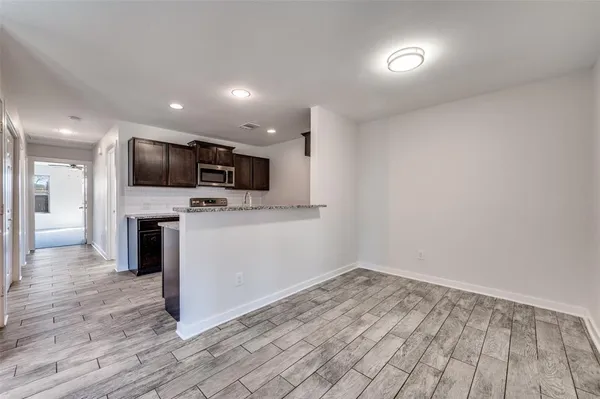 an empty room with wooden floor and a fireplace