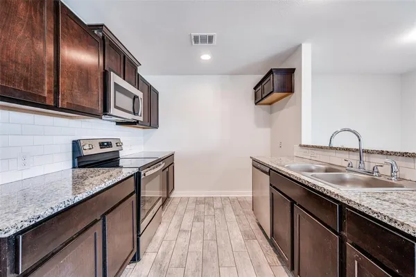 a kitchen with stainless steel appliances granite countertop a sink stove and microwave