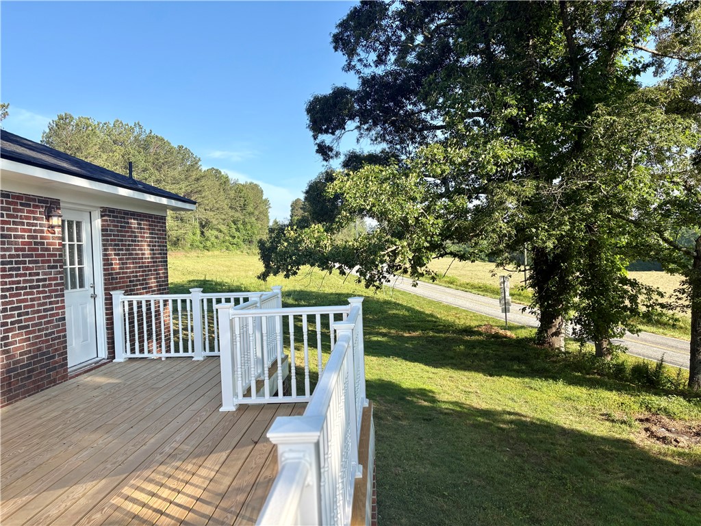 351 Randys Road Westminster, SC 29693 - Photo 17 of 30 A fresh wooden deck with crisp white railings provides tranquil views of the expansive green yard and rural road.