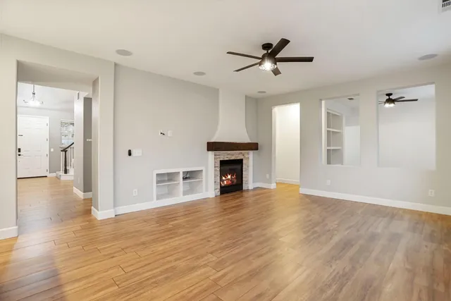 a living room with stainless steel appliances kitchen island a fireplace furniture a fireplace and a ceiling fan