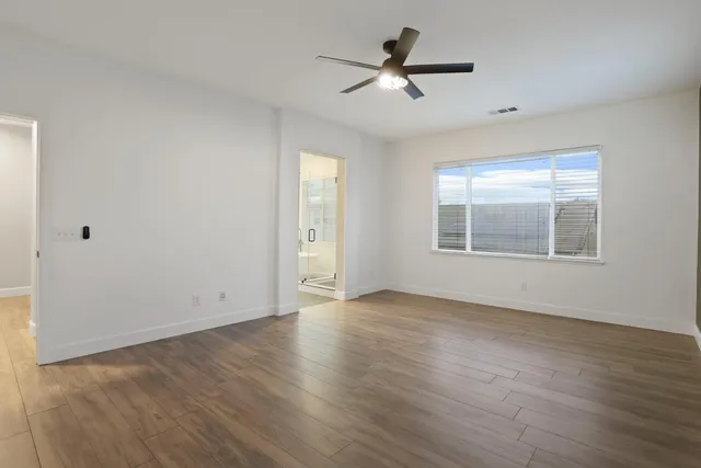 a bathroom with double vanity sinks a toilet a mirror and shower