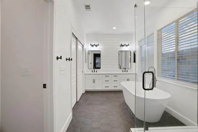 a bathroom with a sink a toilet a mirror and shower