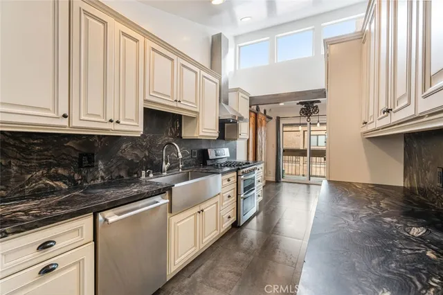 a kitchen with stainless steel appliances granite countertop a sink and a stove