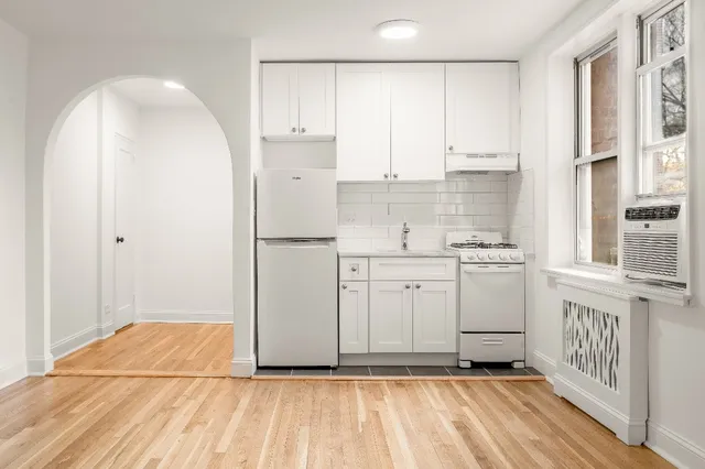 a kitchen with white cabinets and white appliances