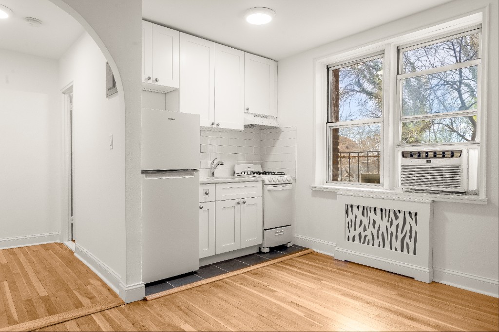 5645 Netherland Avenue, Unit 2F Bronx, NY 10471 - Photo 3 of 12 a view of a kitchen with white cabinets and wooden floor