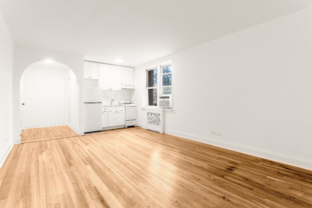 5645 Netherland Avenue, Unit 2F Bronx, NY 10471 - Photo 4 of 12 a view of kitchen and empty room with wooden floor