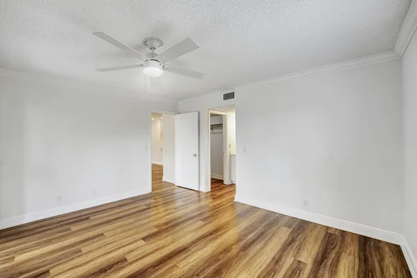a view of an empty room with wooden floor