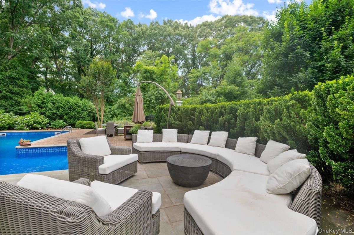 5 Fox Hunt Court Cold Spring Harbor, NY 11724 - Photo 27 of 42 Outdoor living area featuring a swimming pool, stone patio, and lush perimeter landscaping