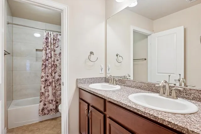 a bathroom with a granite countertop sink a shower and a mirror