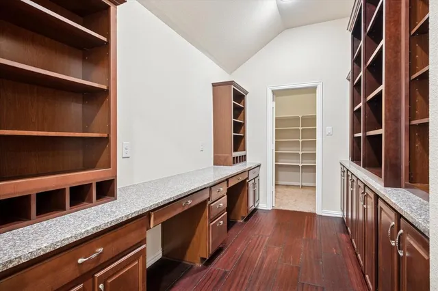 a kitchen with granite countertop a oven a cabinets and wooden floor
