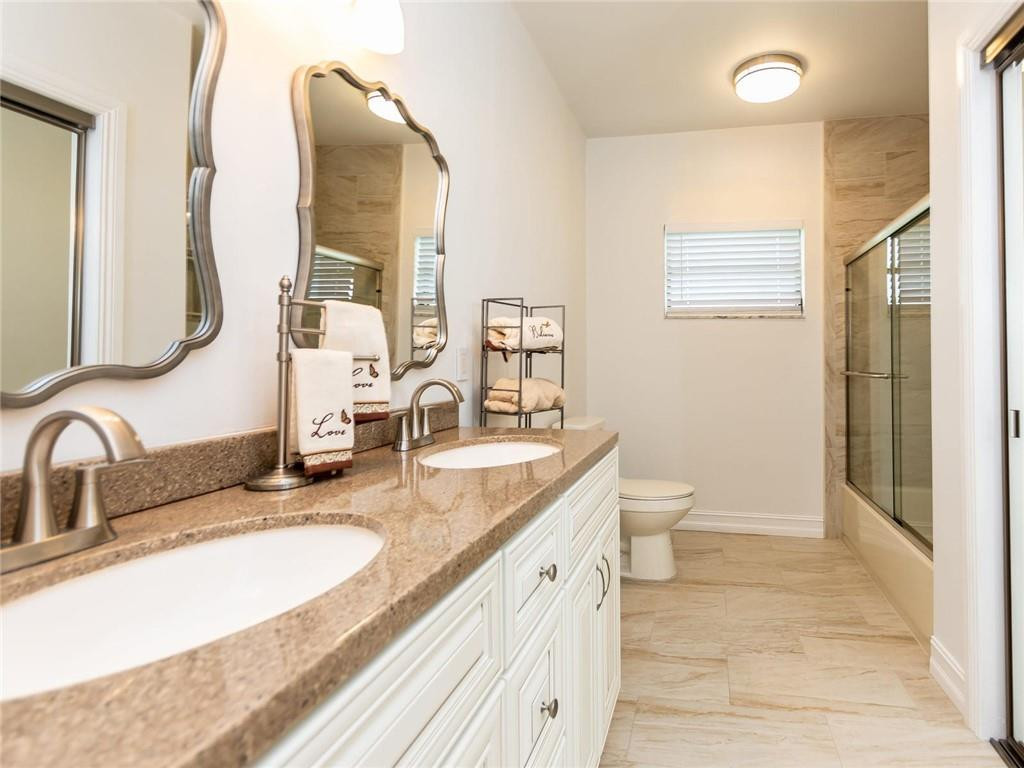 5520 Southwest 166th Avenue Southwest Ranches, FL 33331 - Photo 31 of 50 a bathroom with a granite countertop sink a toilet and a mirror