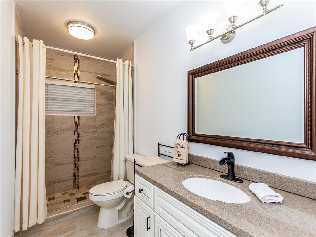 5520 Southwest 166th Avenue Southwest Ranches, FL 33331 - Photo 36 of 50 a bathroom with a granite countertop sink toilet a mirror and shower
