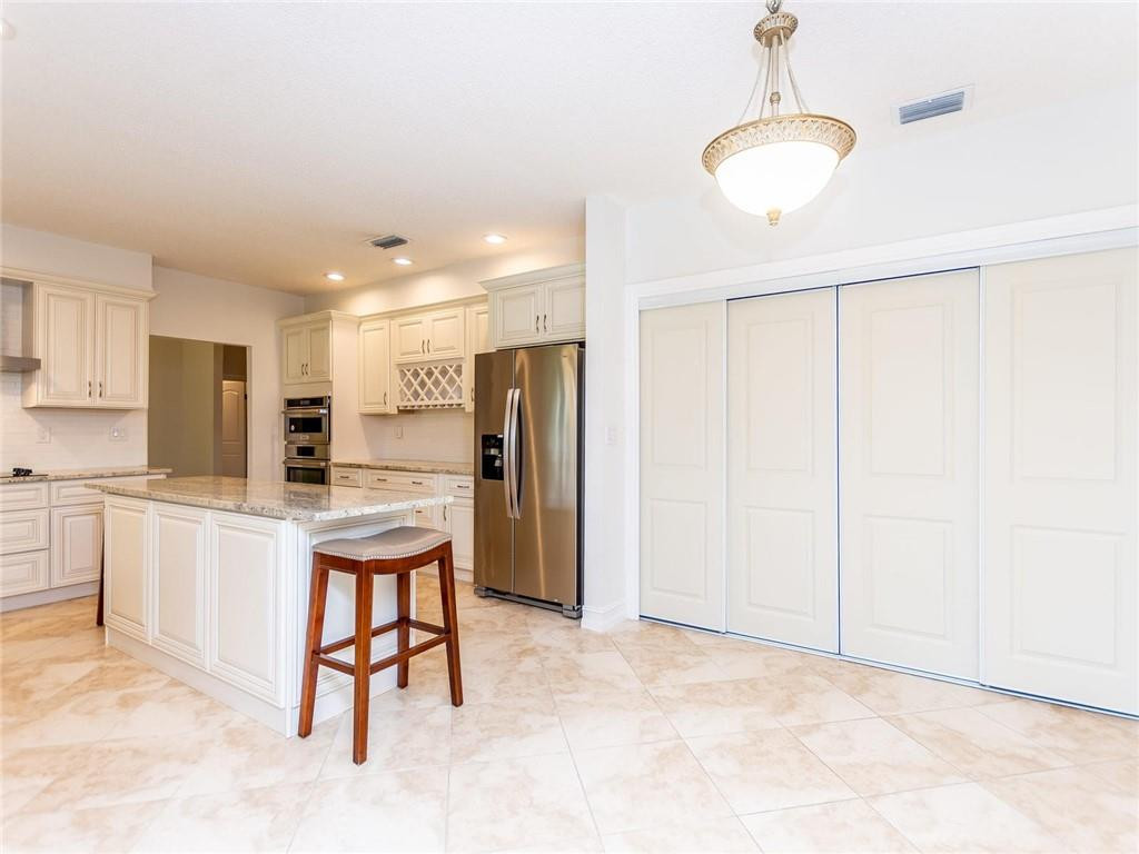 5520 Southwest 166th Avenue Southwest Ranches, FL 33331 - Photo 10 of 50 a kitchen with stainless steel appliances kitchen island granite countertop a refrigerator a stove a microwave oven with white cabinets and wooden floor