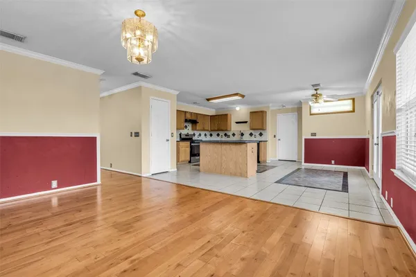 a view of a kitchen with a fridge and wooden floor