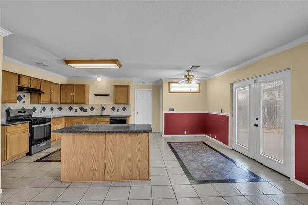 a large kitchen with kitchen island granite countertop a sink counter space and a view of living room