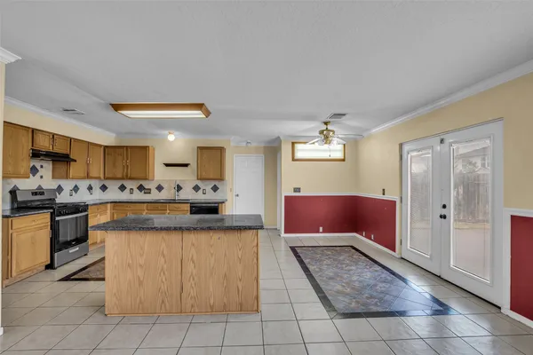 a large kitchen with kitchen island granite countertop a stove a sink dishwasher and a refrigerator