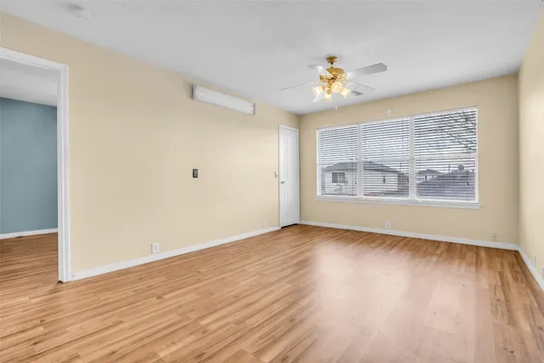 a view of a room with wooden floor and a ceiling fan
