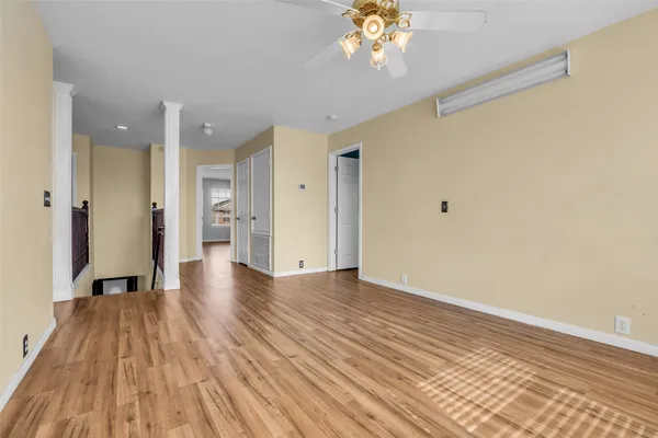 a view of a room with wooden floor and a ceiling fan