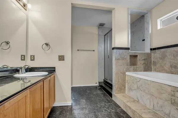 a spacious bathroom with a granite countertop sink a mirror and shower