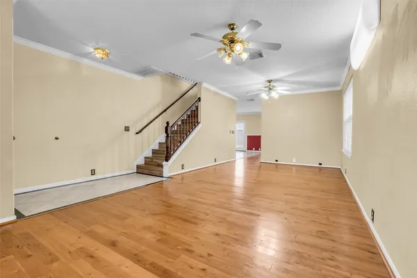 a view of a room with wooden floor and ceiling fan