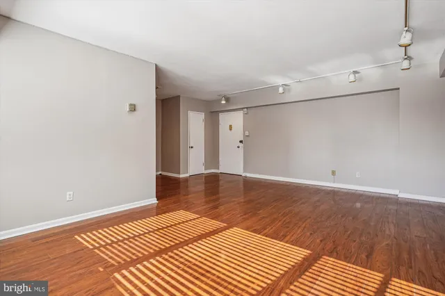 a view of a room with wooden floor and white walls