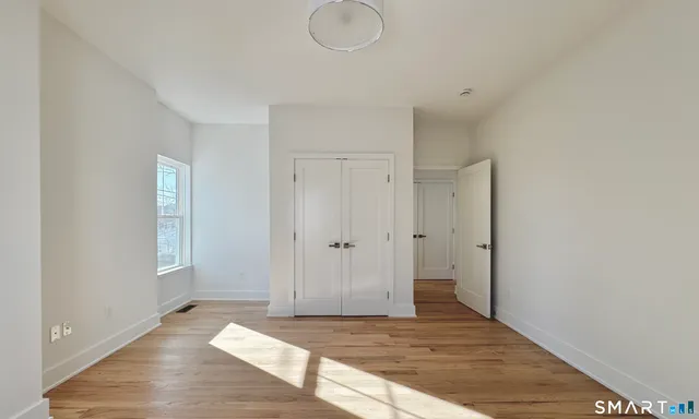 a view of a room with wooden floor and window